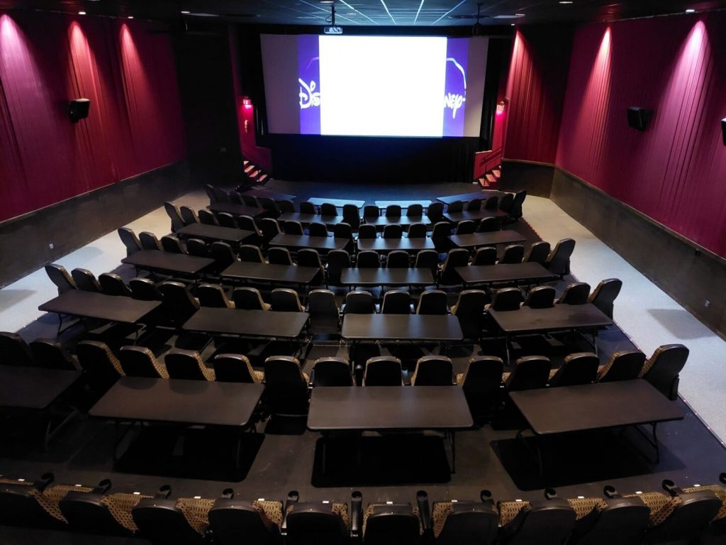 Mariner Theatre in Marinette Wisconsin. Locally Owned Movie Theater. View of the screen and the new luxury high back seats with tables in between each row. 5 feet of space between the rows